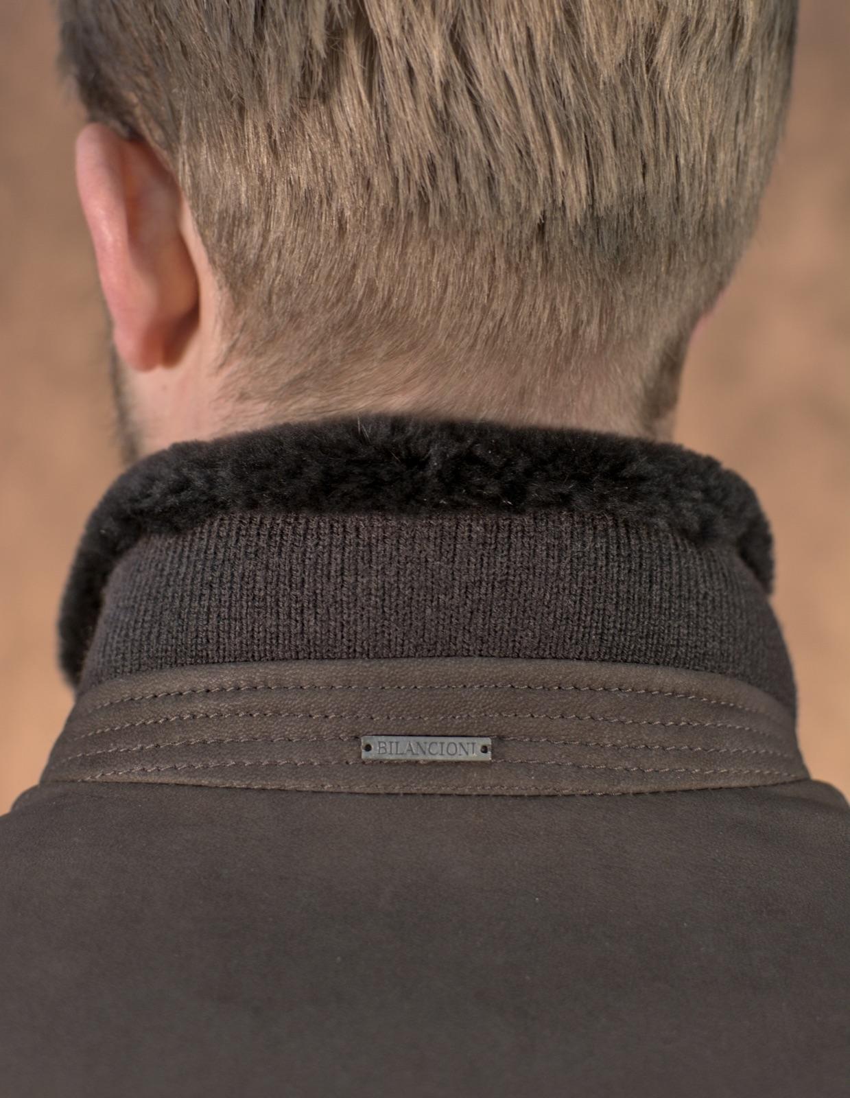 Ribbed knit collar bound in shearling above a stitched leather yoke